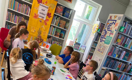 Na zdjęciach uczestnicy Klubu Książki dla dzieci, pani weterynarz z psem, papugi w klatce, książki dla dzieci z serii Klinika pod Boliłapką oraz Julka Mała Weterynarka.